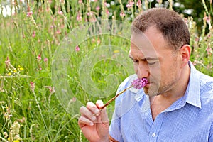 Middle aged male smell of flowers