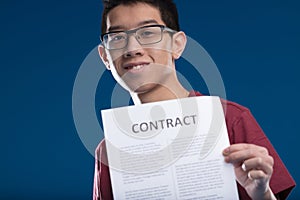 Man joyfully presents contract, symbolizes negotiation skills