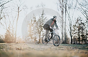 Man joyfully riding a bicycle in a park on a sunny afternoon