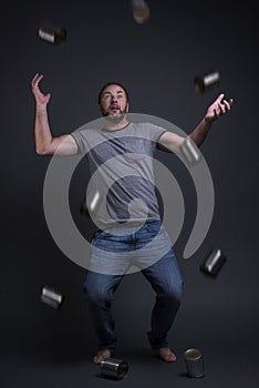 A man juggles with empty cans. photo