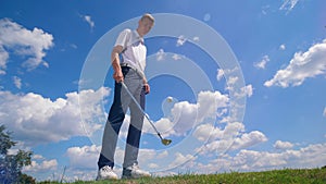 A man juggles golfing ball with a golf club.