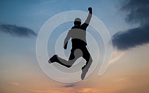 man jump high silhouette full of energy against sunset sky, energy