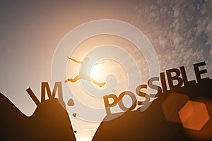 Man jump between impossible wording and possible wording on mountain. Mindset for career growth business photo