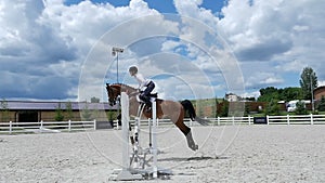 The man jump over barriers on horseback