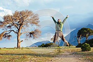 Man jumping into the air over beautiful sunset landscape