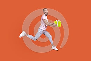 Man jumping in air or running quickly fast to give present box, expressing happiness.