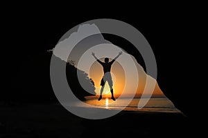 Man jumping on the beach at sunset, beautiful red sky