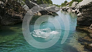 Man jumping into the canyon river with crystal clear blue water for refreshing in hot summer day on vacations. Caucasian