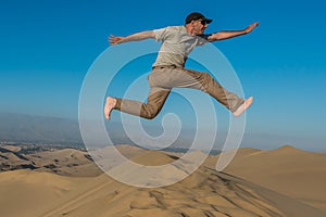 Man jumping desert peruvian coast Ica Peru photo
