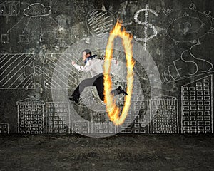 Man jumping through fire hoop with doodles wall