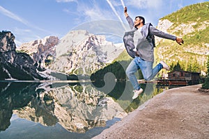 Man jumping at lake beach of mountain lake