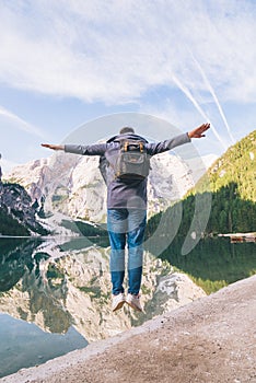 man jumping at lake beach of mountain lake