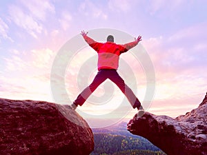 Man jumping from the mountain edge. Man jumping off a cliff without rope. Risky moment.