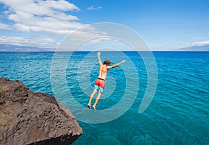 Man jumping off cliff into the ocean