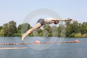 Man jumping off diving board at swimming pool