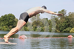 Man jumping off diving board at swimming pool