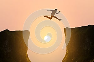 Man jumping over the cliff, silhouette