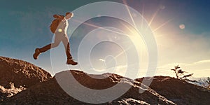 Man jumping over gap on mountain hike