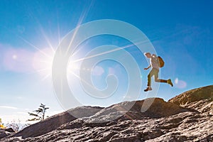 Man jumping over gap on mountain hike photo