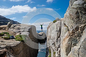 Man jumping over Kjeragbolten in Norway. Kjerag photo