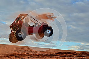 Man Jumping Quad Through the Air on Sand Dune