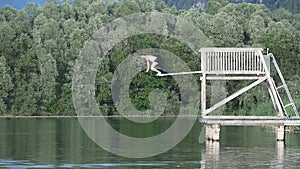 Man jumping from springboard into the lake