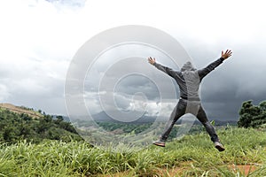 Man jumping on top of mountain hill, Freedom climber on high valley outdoor landscape.