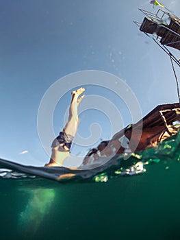 man jumping from tower to lake water