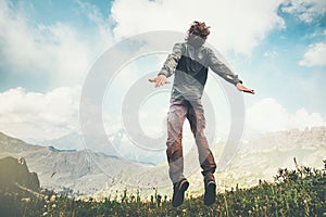 Man jumping up at mountains to clouds sky