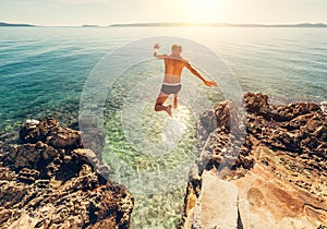 Man jumps in blue sea lagune water