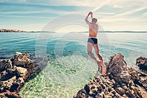 Man jumps in clear crystal water on Adriatic Sea Bay