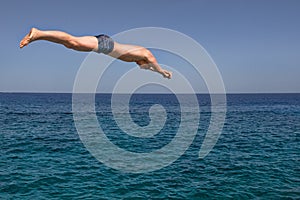 Man jumps into the sea in a sunny day