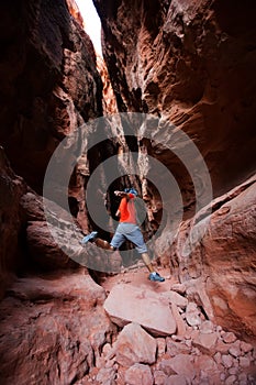 A man jumps from stone in Jenny`s canyon within Snow canyon