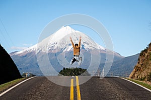 Man jumps in victory success winning pose in front of mountain peak