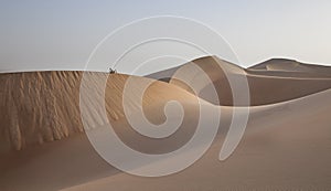 Man in kandura in a desert resting