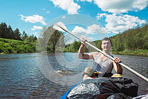 Man in kayak trip rowing boat on the river, a water hike, a summer adventure. Eco-friendly and extreme tourism, active and healthy