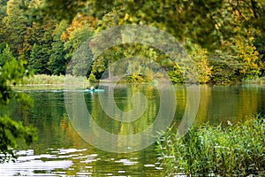 Man kayaking on the Balsys lake, one of six Green Lakes, located in Verkiai Regional Park. Exploring nature on autumn day in