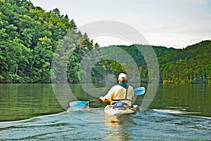Man Kayaking on Quiet Lake