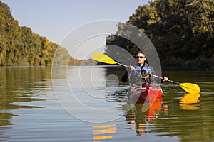 The man is kayaking on the river.