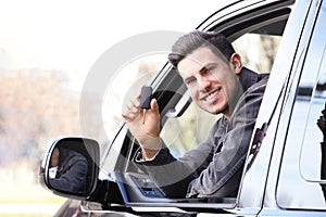 Man with key sitting in car. Buying new auto