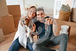Man with keys. Young couple with dog are moving to new home