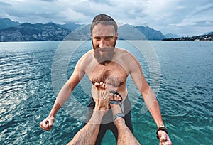 The man is kicked into the water from the pier