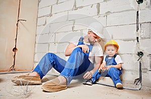 Man showing tool to child in apartment under renovation.