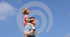 Man with kid on shoulders pointing away