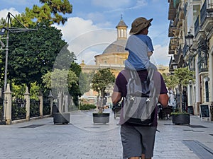 Man with kid on shoulders walk beautiful Valencia streets photo