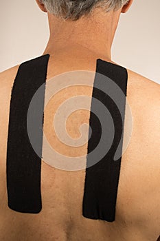 Man with Kinesio Tape on his back for pain