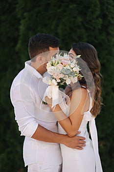 Man kiss woman and hide by bouquet. Wedding day