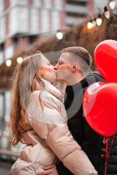 A man kisses a charming girl, two people stand and kiss each other