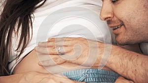 Man kisses his pregnant wife`s belly