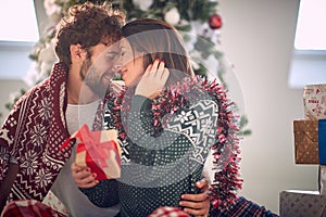Man kisses woman while gives her Christmas gift